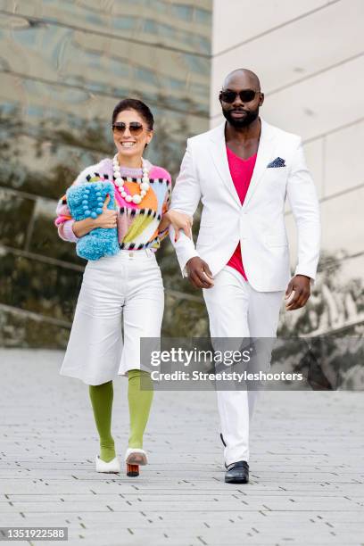 Influencer Salome Chaboki, wearing a multicolor mohair-blend knit sweater by Essential Antwerp, white bermuda shorts by Acne Studios, a blue faux fur...