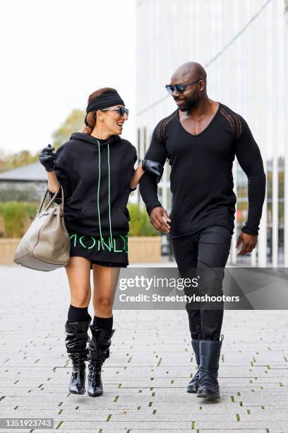 Influencer Salome Chaboki, wearing a black hoodie unisex Sam by Mondenero.EU, a black oversize shirt with neon green print by Mondenero.EU, black...