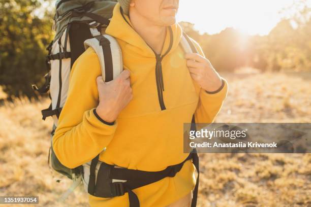 smiling young man wearing backpack standing on autumn forest trail. - fleece stockfoto's en -beelden