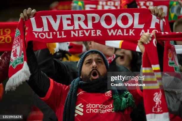 Liverpool fan holds up his scarf whilst singing 'You'll Never Walk Alone' before the UEFA Champions League group B match between Liverpool FC and...