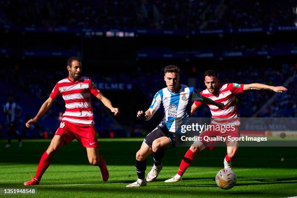 Adria Pedrosa of RCD Espanyol competes for the ball with Quini Marin and Victor Diaz of Granada CF during the La Liga Santander match between RCD...