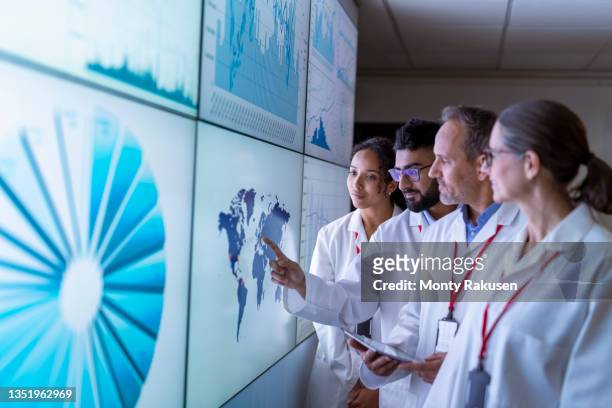 uk, york, team of researchers inspecting charts on interactive screens - partnership infographic stock pictures, royalty-free photos & images