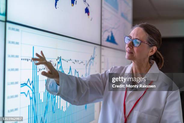 uk, york, female researcher inspecting charts on interactive screens - scientist bildbanksfoton och bilder