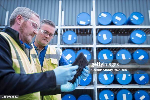 uk, manchester, workers using digital tablet in oil blending plant - oil barrel stock pictures, royalty-free photos & images