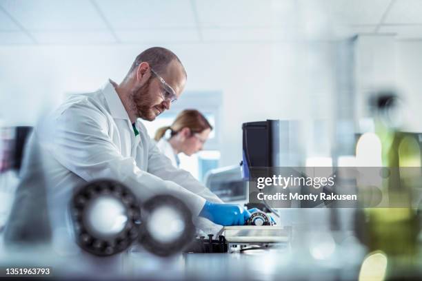 uk, manchester, laboratory workers testing bearing lubricant - lubricación fotografías e imágenes de stock