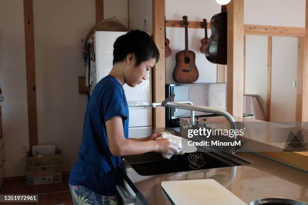 boy washing dishes in kitchen - role reversal stock pictures, royalty-free photos & images