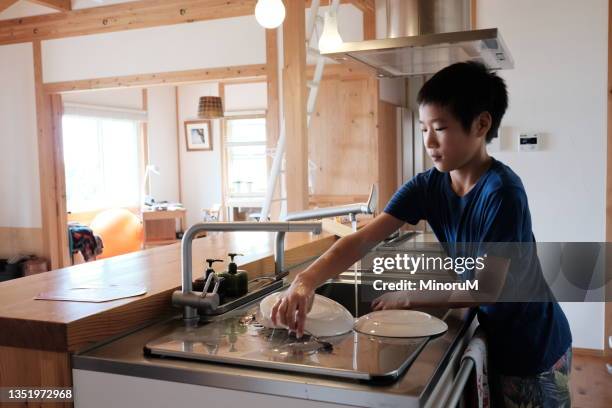 boy washing dishes in kitchen - children housework stock pictures, royalty-free photos & images