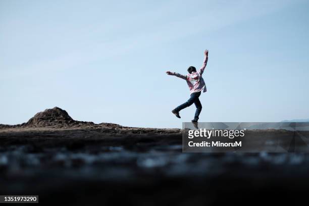 boy jumping by the seaside cliff - 日常の一コマ ストックフォトと画像