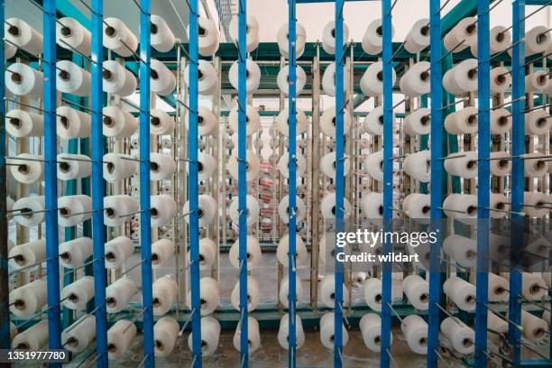 white yarn spools bobbin thread cones in a order on industrial warping knitting beaming machine in textile factory - thread stock pictures, royalty-free photos & images
