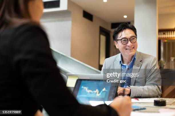 two asian business professionals in business suit working together in co-working office - staff wellbeing stock pictures, royalty-free photos & images