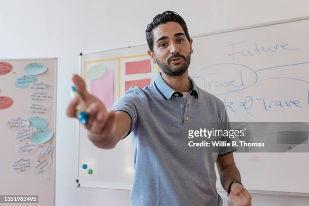 high school teacher talking to students during class - man standing and gesturing stock-fotos und bilder