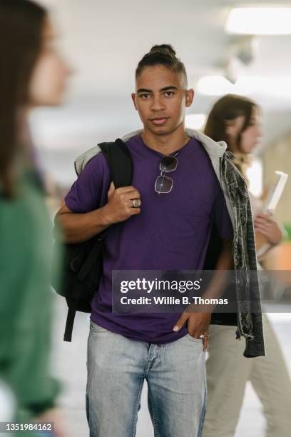 high school student with bag on one shoulder - purple shirt stock pictures, royalty-free photos & images