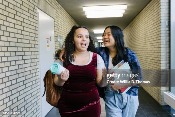 two best friends walking down corridor at school - sólo chicas adolescentes fotografías e imágenes de stock