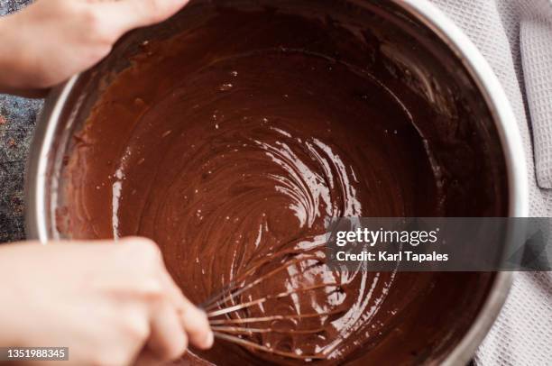 mixing chocolate dough for baking on a mixing bowl - mixing bowl stock pictures, royalty-free photos & images