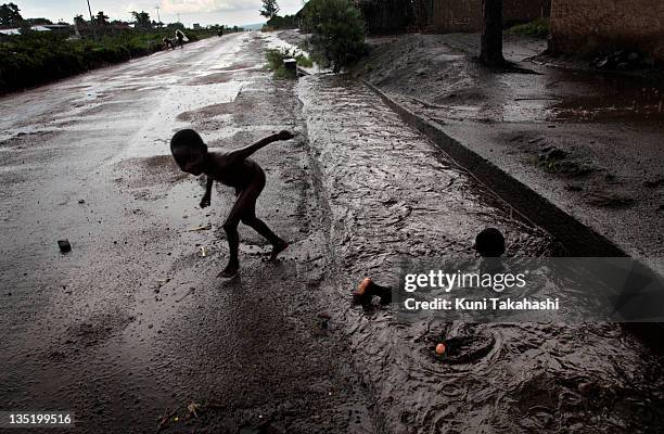 Children swim in the gutter April 26, 2010 on the outskirts of Goma, Democratic Republic of Congo. The long war had involved 9 African nations and...