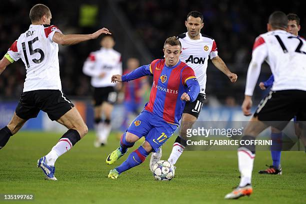 Basel's midfielder Xherdan Shaqiri controls the ball between Manchester United's Serbian defender Nemanja Vidic Welsh midfielder Ryan Giggs and...