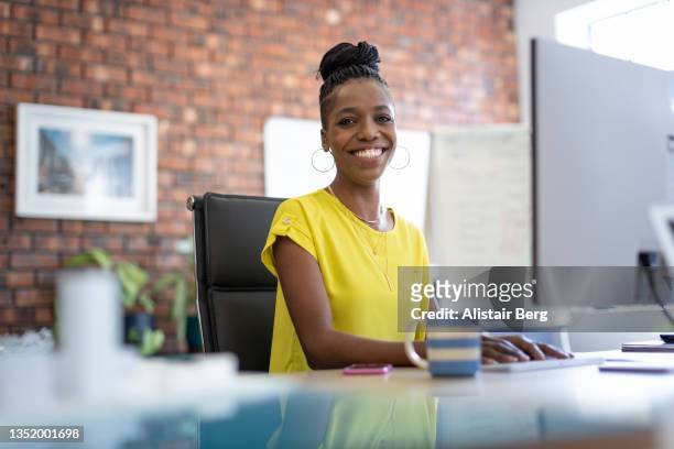 portrait of smiling woman working in an office - sekretärin stock-fotos und bilder