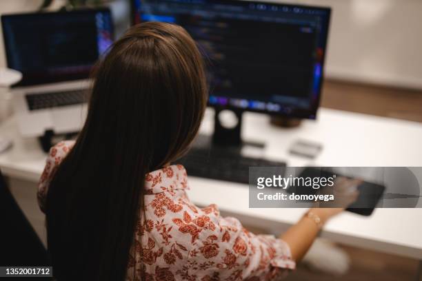 female programmer using a computer in the office - software as a service stock pictures, royalty-free photos & images