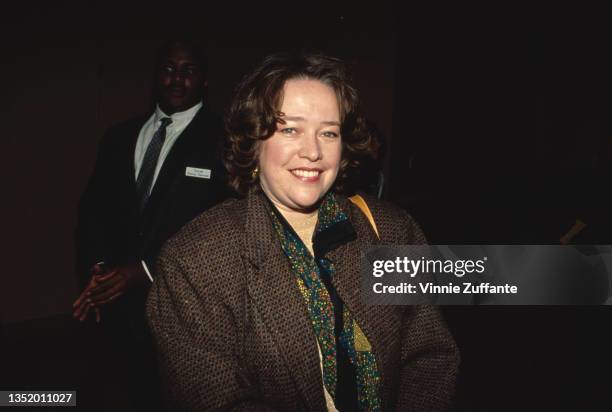 American actress Kathy Bates, wearing a tweed jacket with a spotted scarf, attends an event, circa 1992.