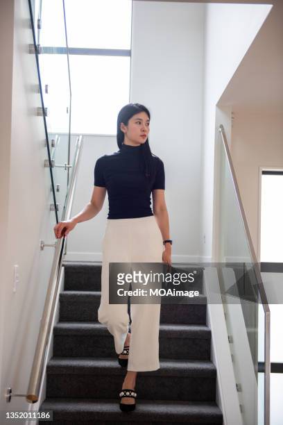 young stylish businesswoman walking down the stairs - man fallen up the stairs stock-fotos und bilder