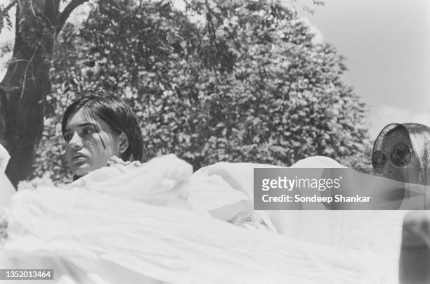 Widowed Maneka Gandhi and mother Indira Gandhi accompany Sanjay's body who died in a plane crash during the funeral procession on June 25, 1980 in...