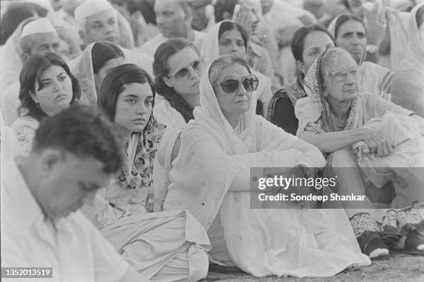 Prime Minister Indira Gandhi with Maneka gandhi sit on the ground during the cremation of Sanjay Gandhi in New Delhi on June 25, 1980.