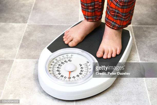 overweight boy on scales - childhood obesity stock pictures, royalty-free photos & images