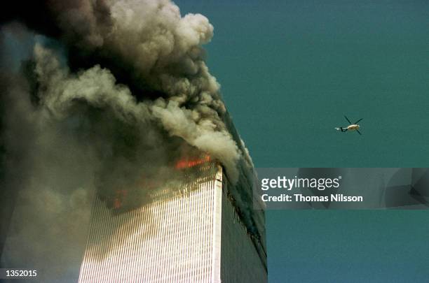 Police helicopter hovers over the World Trade Center's north tower September 11, 2001 in New York City.