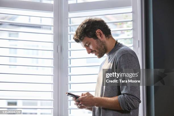 young man looking at mobile phone. - beards jewellery london stock-fotos und bilder