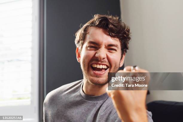 young man cheering at camera. - fist celebrating fotografías e imágenes de stock