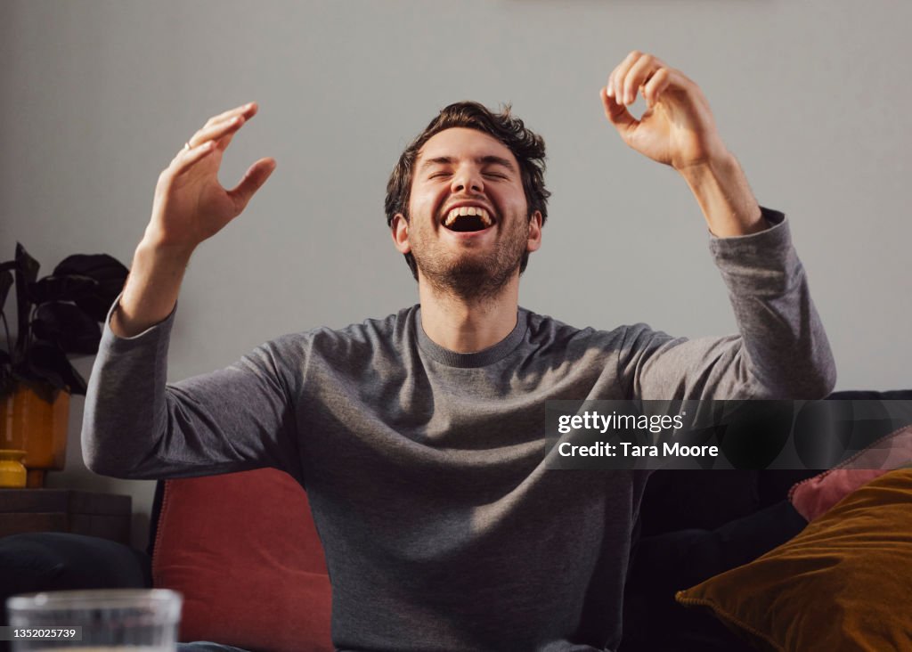 Young man cheering with his arms raised.