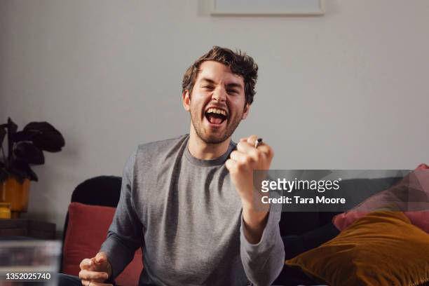 young man cheering at camera. - navy blue living room stock pictures, royalty-free photos & images