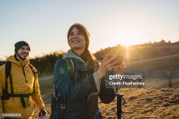 joyful woman, can’t hide her delight of the majestic nature, during her hike with a boyfriend - mobile phone and adventure stockfoto's en -beelden