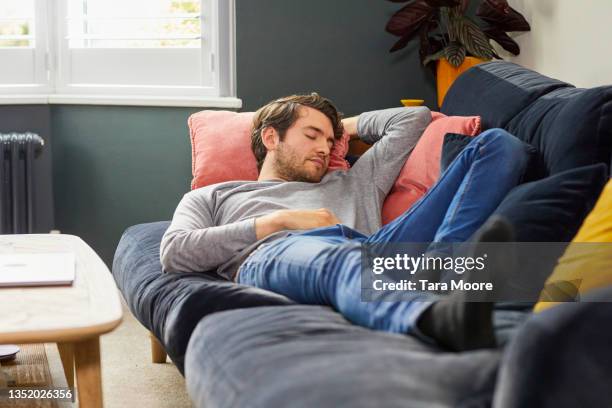 young man asleep. - man couch foto e immagini stock