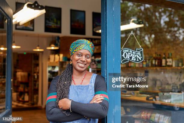 portrait of black female shop owner in shop door way. - mature cafe happy stock-fotos und bilder