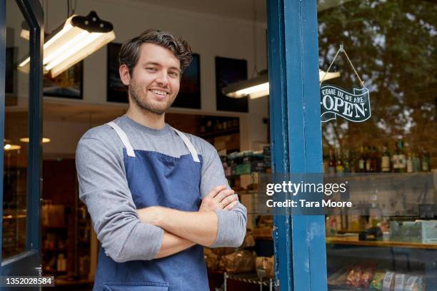 portrait of shop worker in shop door way. - aushilfsverkäufer stock-fotos und bilder