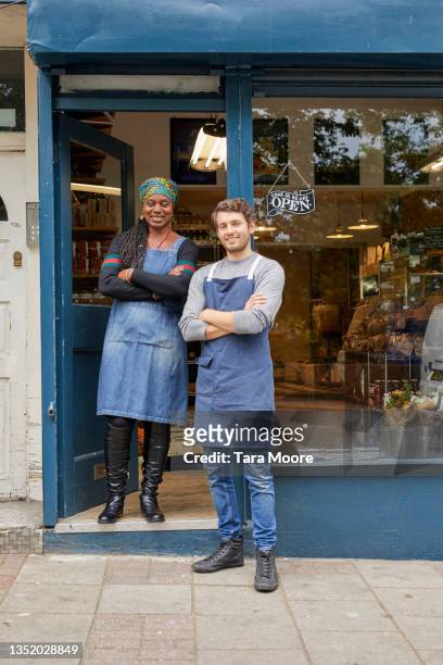 woman and man standing in front of their store. - open sign stock pictures, royalty-free photos & images