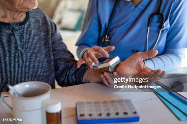 unrecognizable caregiver measuring pressure to senior man indoors at home during home visit. - house call stock pictures, royalty-free photos & images