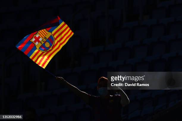 Fans are seen waving flags inside the stadium as they await the unveiling of new FC Barcelona Head Coach Xavi Hernandez during a press conference at...