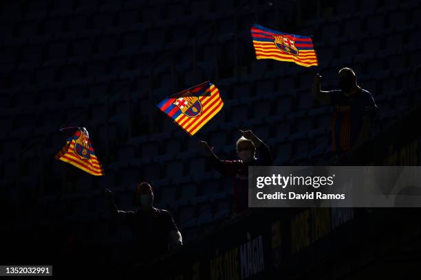 Fans are seen waving flags inside the stadium as they await the unveiling of new FC Barcelona Head Coach Xavi Hernandez during a press conference at...