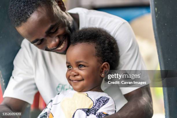 father hugging his little daughter - cultura afro americana stock-fotos und bilder