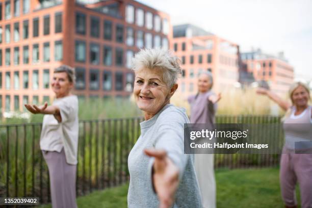 group of senior women doing exercise outdoors in town park. - slovakia town stock pictures, royalty-free photos & images