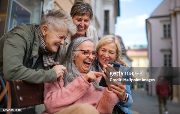 group of happy senior women on a walk in city, taking selfie. - senior women group stock pictures, royalty-free photos & images