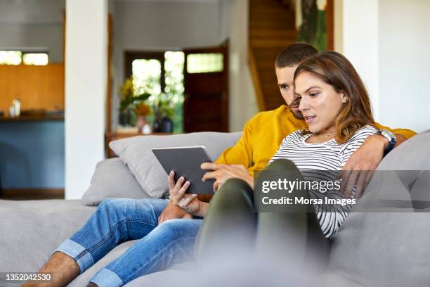 mid adult couple watching movie on digital tablet - young couple at movie together imagens e fotografias de stock