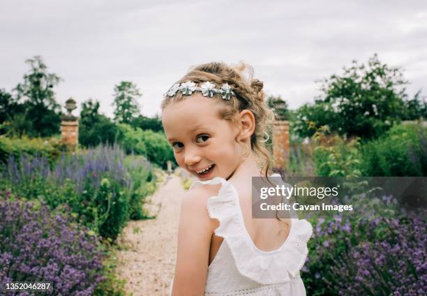 young flower girl smiling at a wedding in a beautiful field of flowers - small wedding fotografías e imágenes de stock