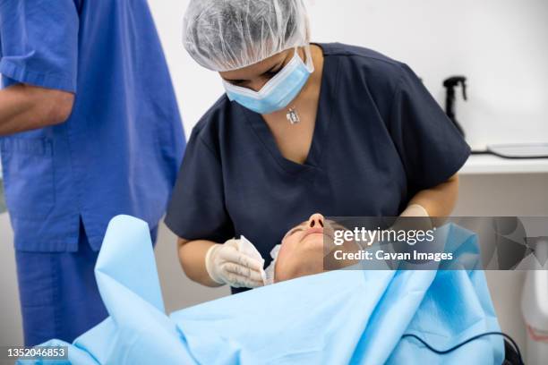 surgeons performing eyelid surgery to anonymous patient - eyelid foto e immagini stock