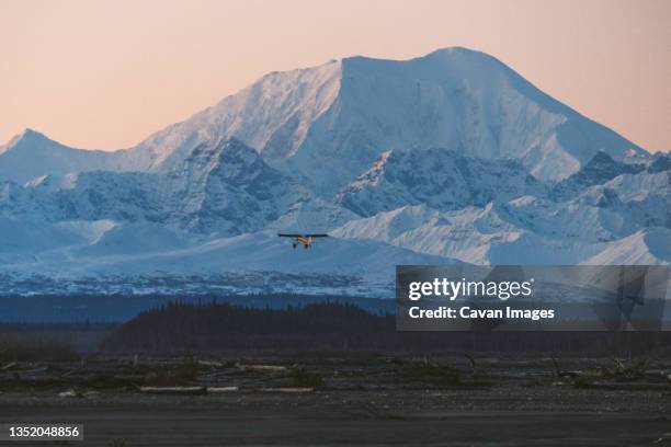 a small plane flies in front of mt foraker of the alaska range a - talkeetna stock pictures, royalty-free photos & images