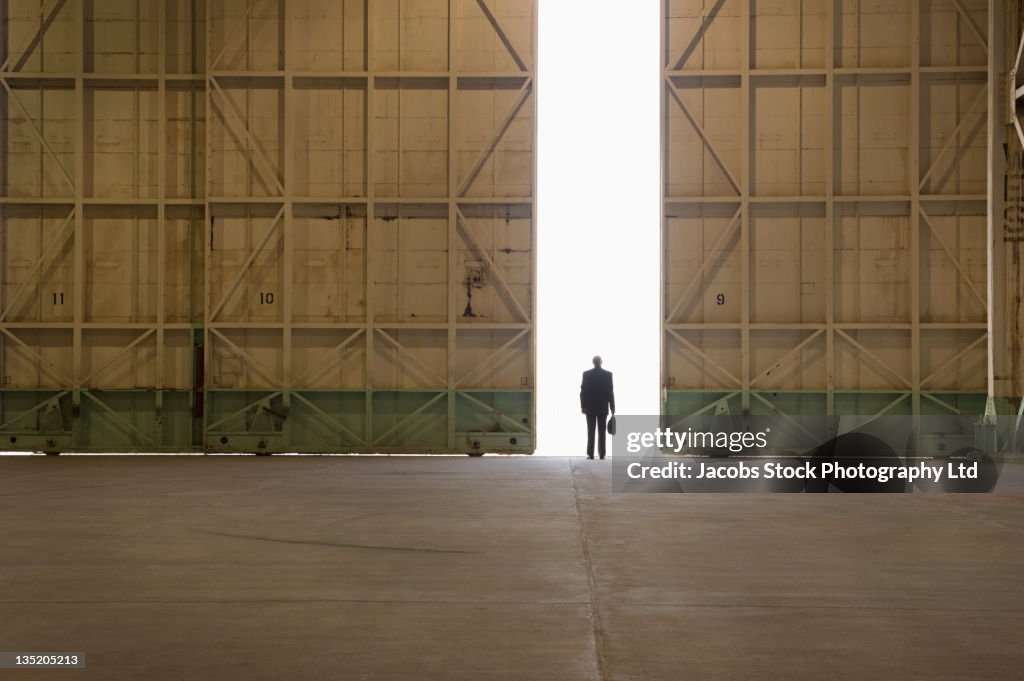 Caucasian businessman standing in warehouse doorway
