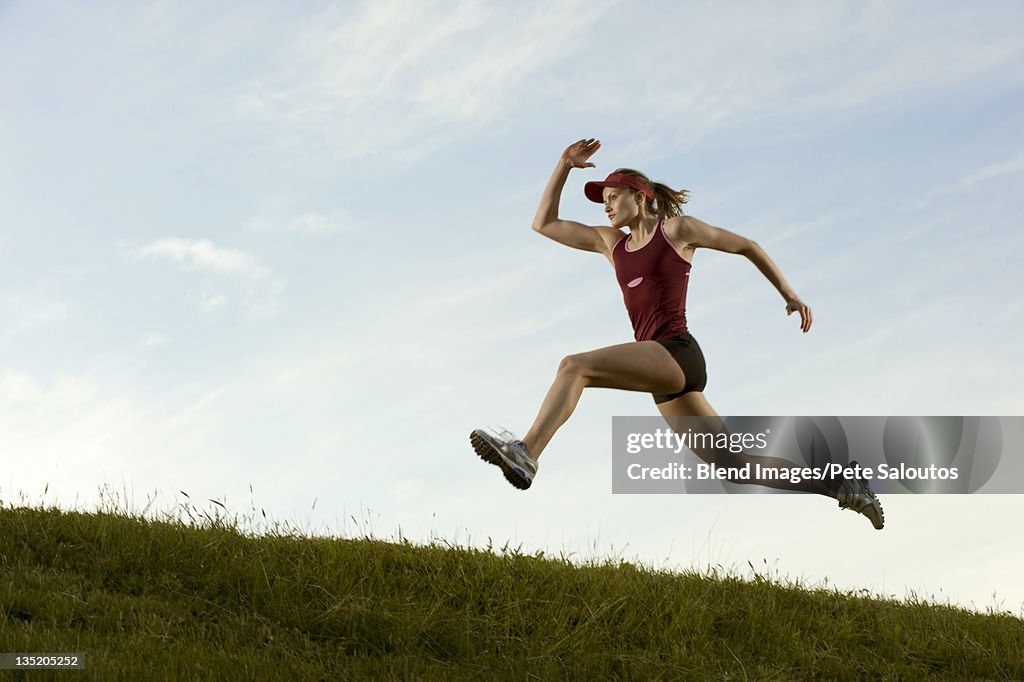 Caucasian runner running in field