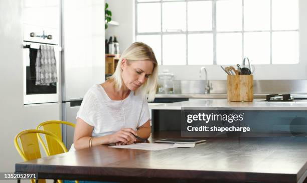 shot of a woman reading through contracts before signing them - form filling stock pictures, royalty-free photos & images